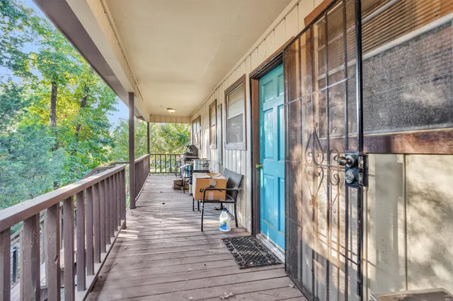 a view of a balcony with chairs and wooden floor