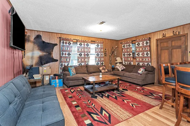 a living room with furniture a rug and a bookshelf