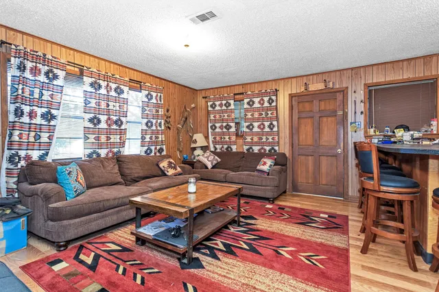a living room with furniture a rug and a large window
