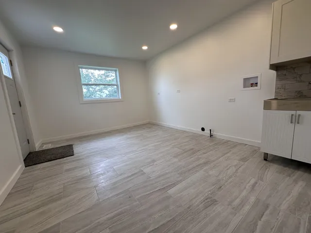 a view of a livingroom with wooden floor and a ceiling fan