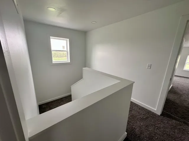 a view of a hallway with closet and wooden floor