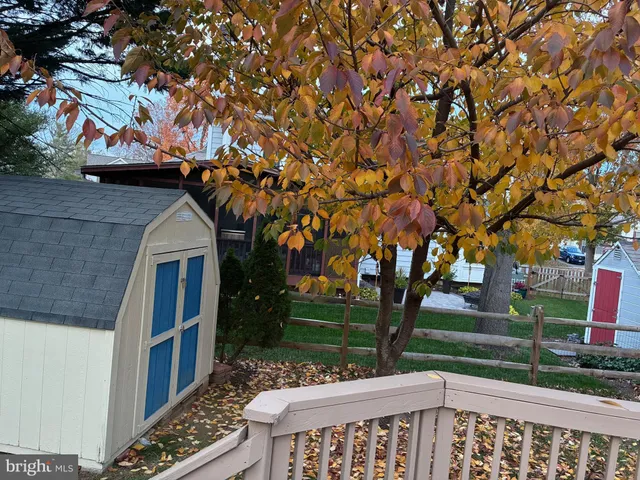 a view of a white house with a big yard and large trees