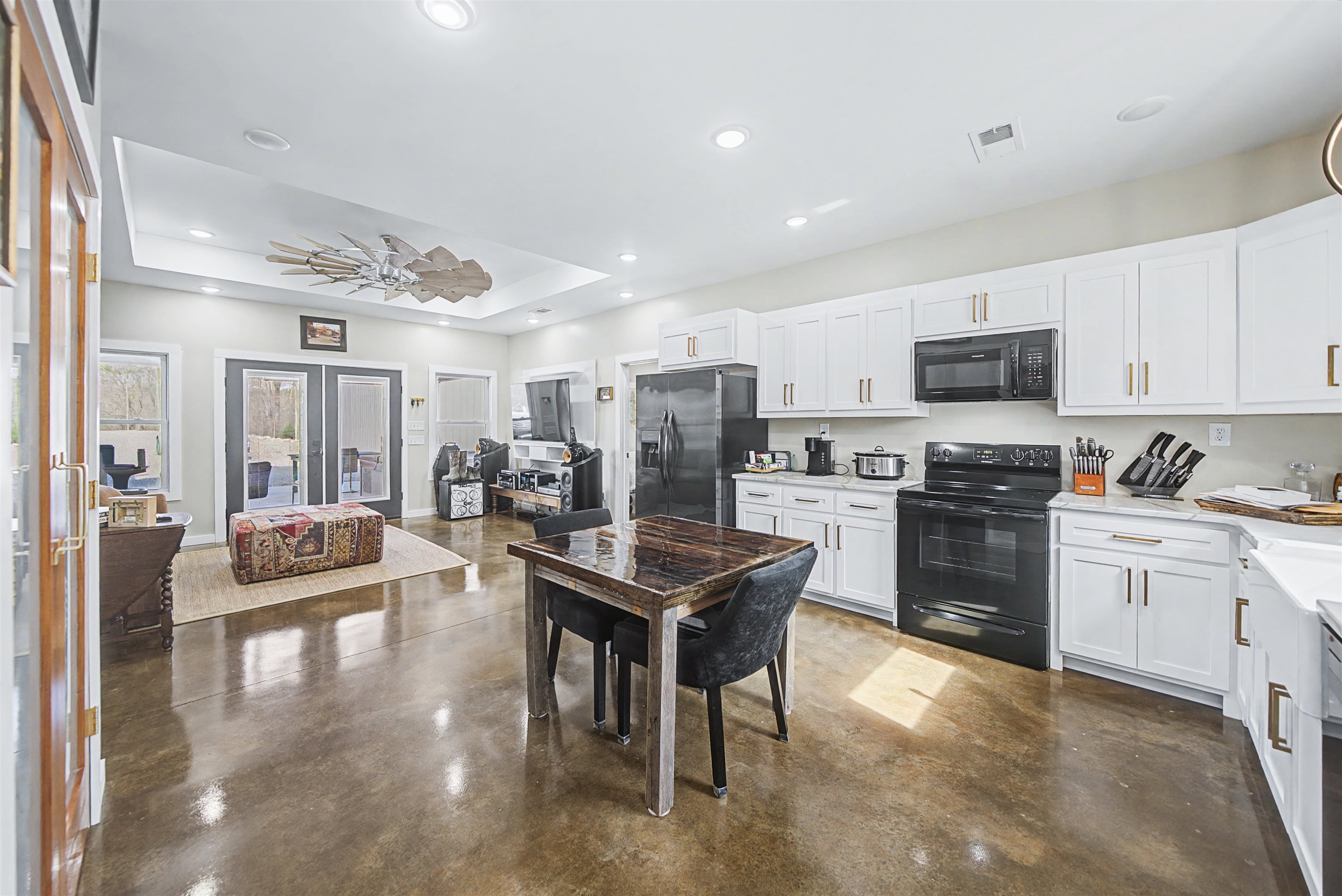 5439 Hines Gin Road Selmer, TN 38375 - Photo 11 of 33 a kitchen with stainless steel appliances granite countertop a stove top oven a sink dishwasher a dining table and chairs with wooden floor
