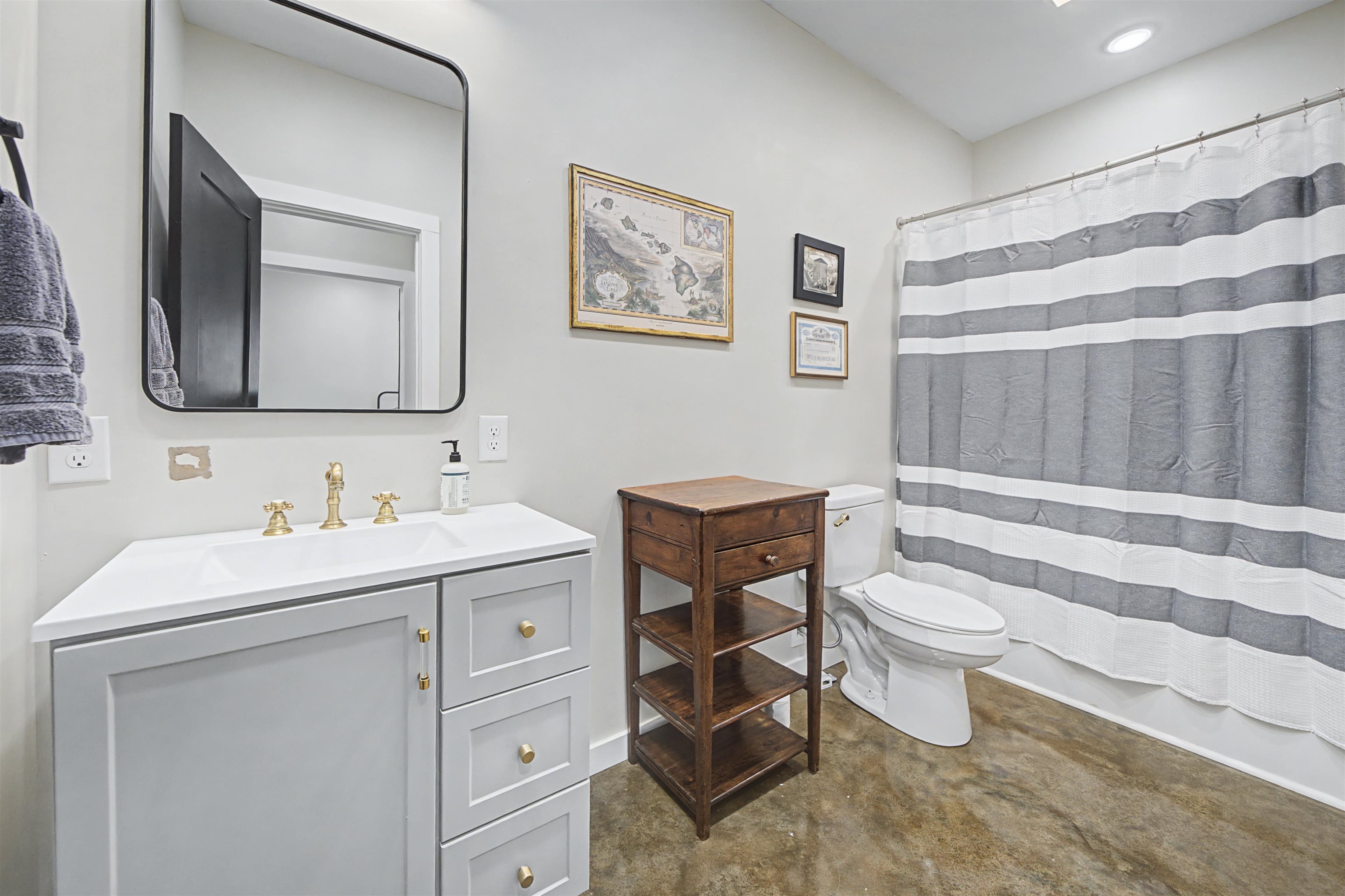 5439 Hines Gin Road Selmer, TN 38375 - Photo 21 of 33 a bathroom with a toilet a sink a mirror a bathtub and vanity