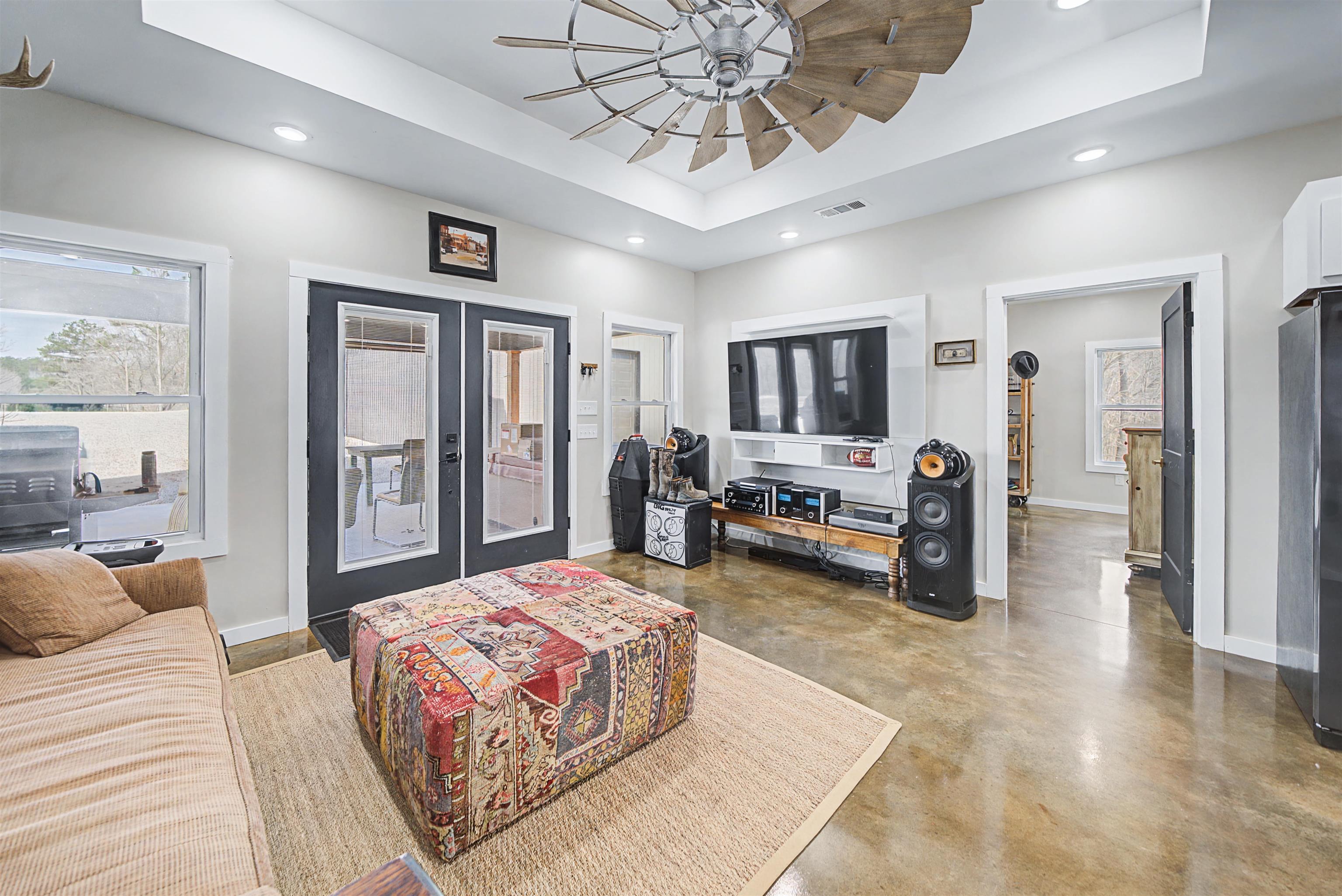 5439 Hines Gin Road Selmer, TN 38375 - Photo 7 of 33 a spacious bedroom with a bed a couch and a chandelier