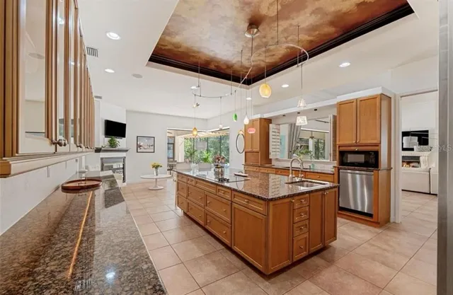 a large kitchen with stainless steel appliances granite countertop a large counter top a stove and a shower