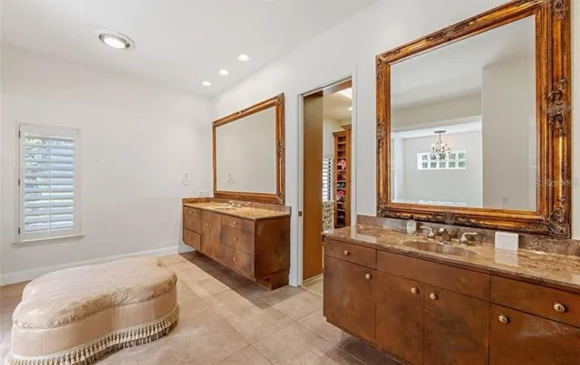 a spacious bathroom with a double vanity sink a mirror and a bathtub