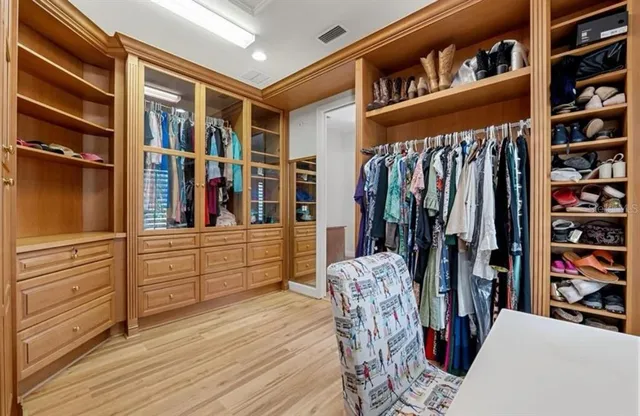 a view of walk in closet with clothes and shoes