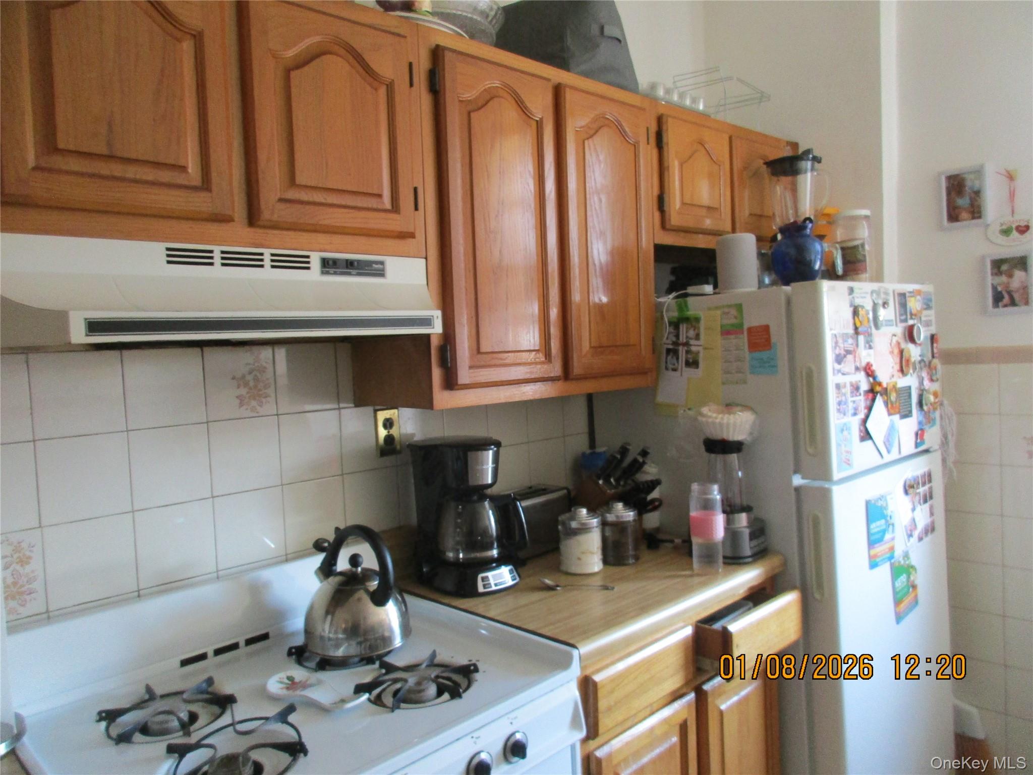 68-09 79th Street Queens, NY 11379 - Photo 13 of 15 a kitchen with stainless steel appliances granite countertop a sink refrigerator and cabinets