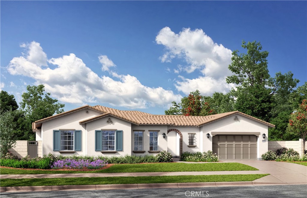 a front view of a house with a garden and trees