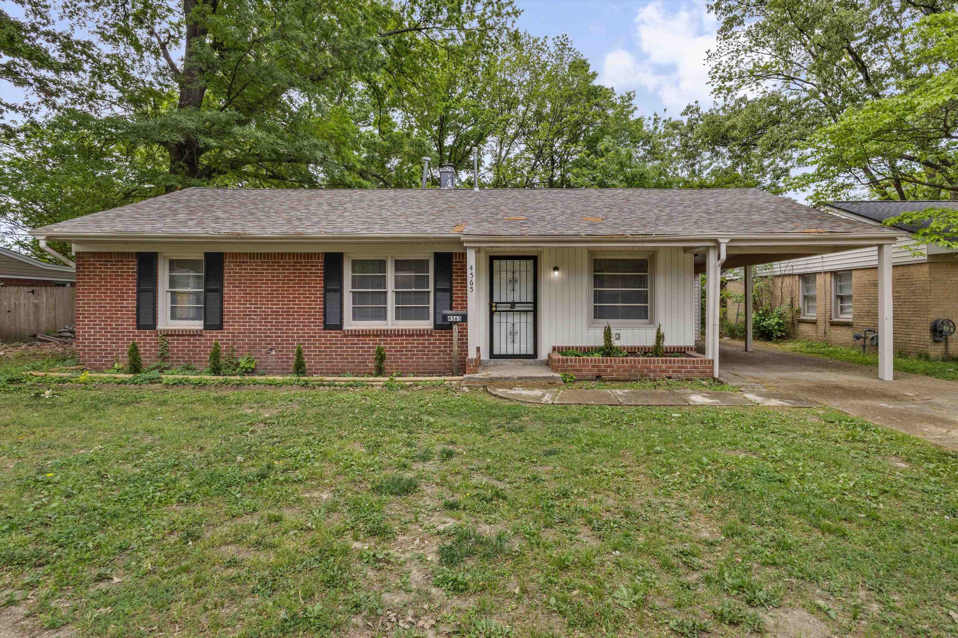 4565 Verne Road Memphis, TN 38117 - Photo 1 of 18 Brick and siding exterior featuring a covered carport, front entry with security door, and a shingle roof