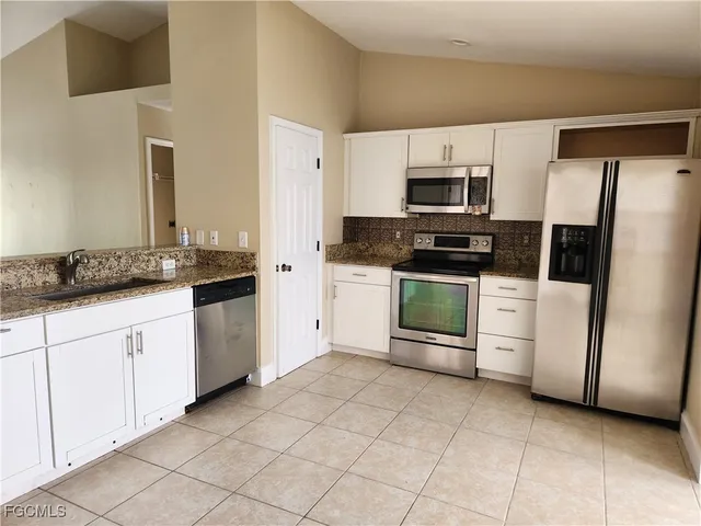 a kitchen with stainless steel appliances granite countertop a refrigerator and a stove top oven