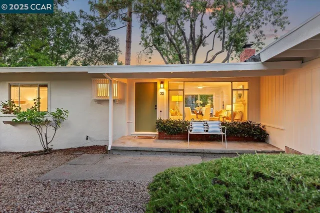 a view of a porch with a floor to ceiling window and potted plants