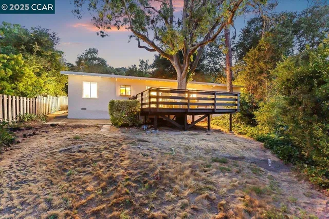 a view of backyard with wooden fence and a bench