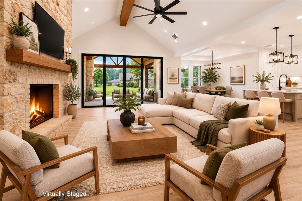 120 Springwood Road Enchanted Oaks, TX 75156 - Photo 6 of 37 Vaulted ceiling living area featuring a stone fireplace, wood-finish flooring, and a ceiling fan