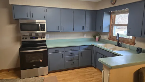 a kitchen with a sink dishwasher a stove and a microwave oven with cabinets
