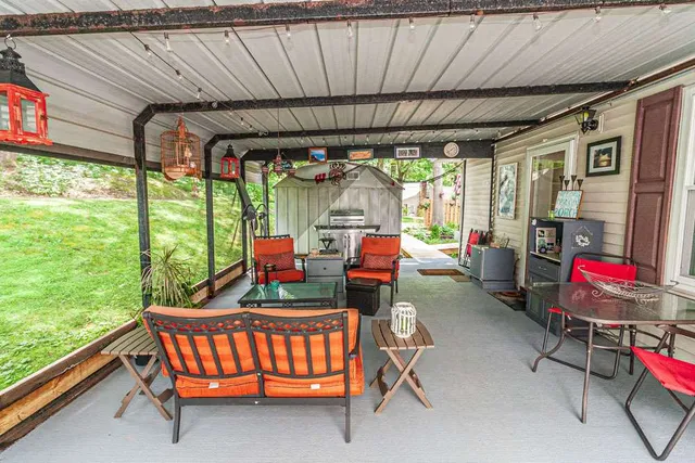 a living room with patio furniture and a floor to ceiling window