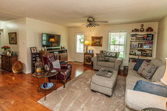 a living room with furniture a flat screen tv and a window