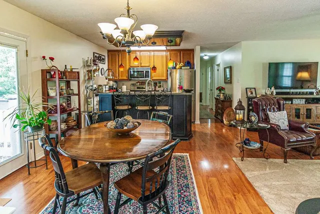 a dining room filled chandelier and wooden floor