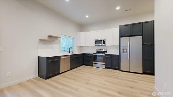 a large kitchen with a refrigerator and a stove top oven