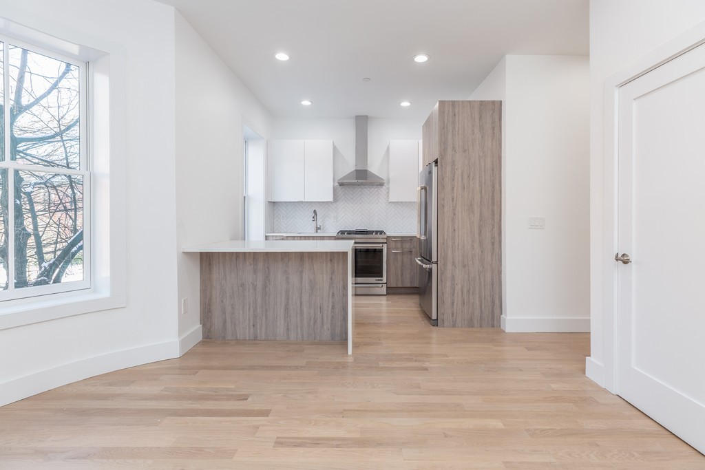 a kitchen with kitchen island granite countertop a sink cabinets and stainless steel appliances