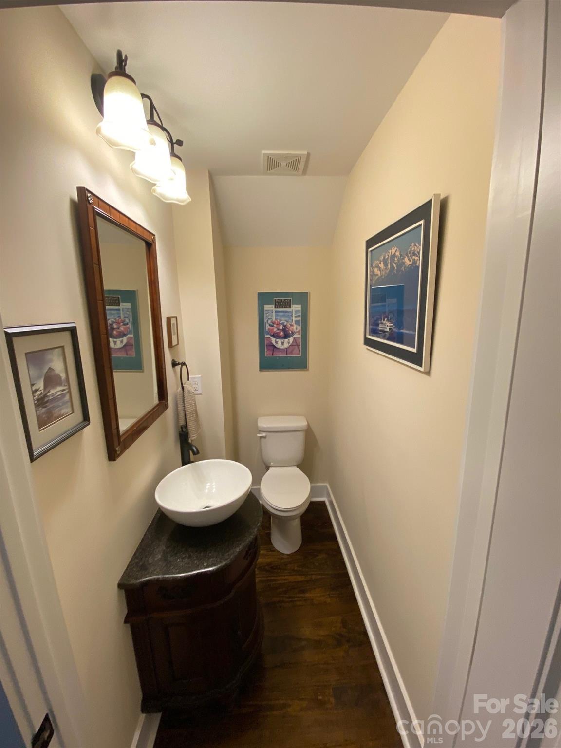 201 Main Street Matthews, NC 28105 - Photo 7 of 16 a bathroom with a toilet a sink and a mirror
