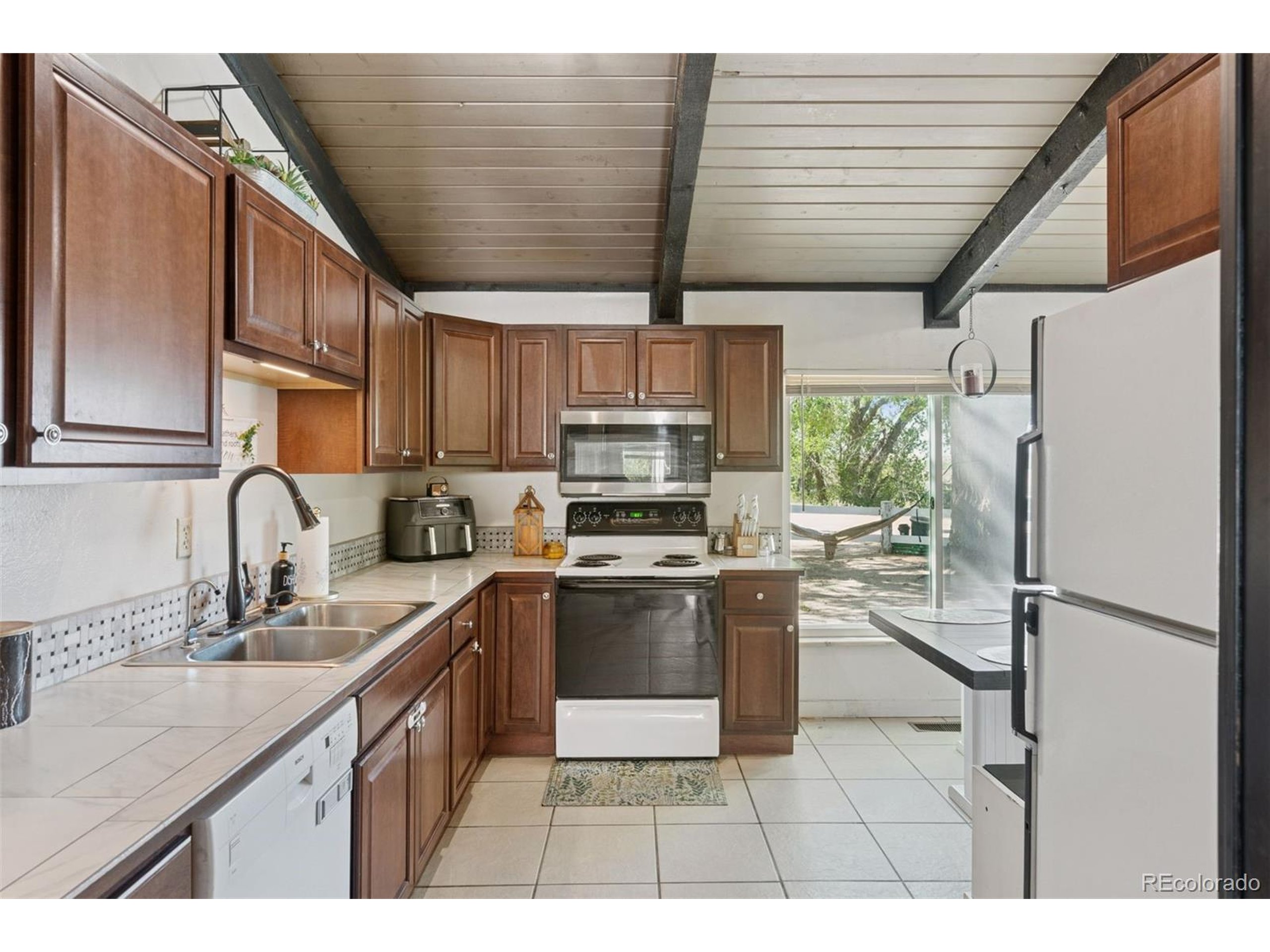 16880 Old Pueblo Road Fountain, CO 80817 - Photo 27 of 49 a kitchen with stainless steel appliances granite countertop a sink a stove a refrigerator cabinets a sink and a stove