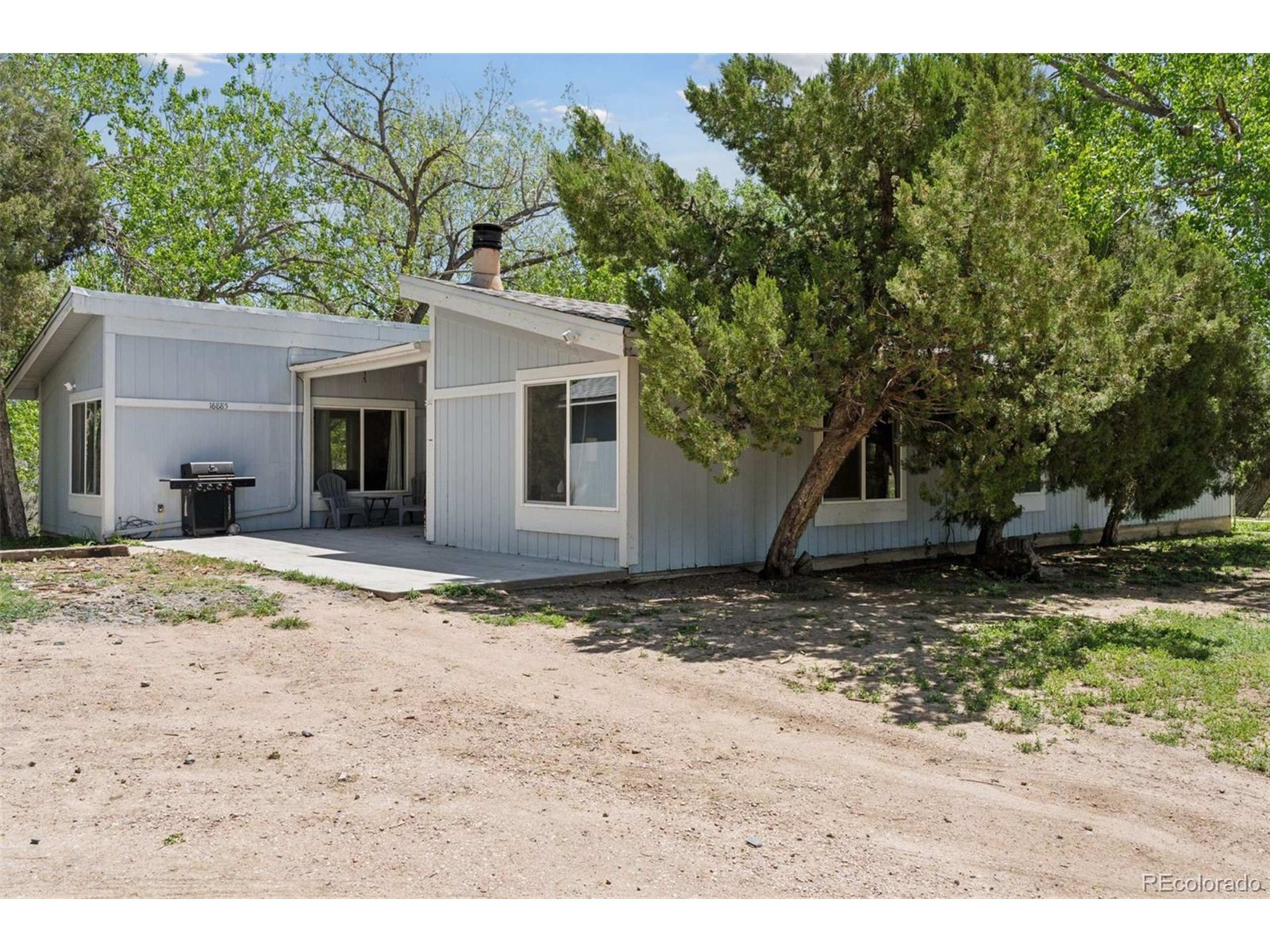 16880 Old Pueblo Road Fountain, CO 80817 - Photo 9 of 49 a view of a yard with a house and a tree