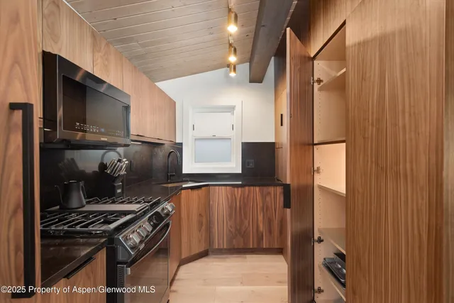 a kitchen with stainless steel appliances granite countertop a refrigerator and a stove top oven