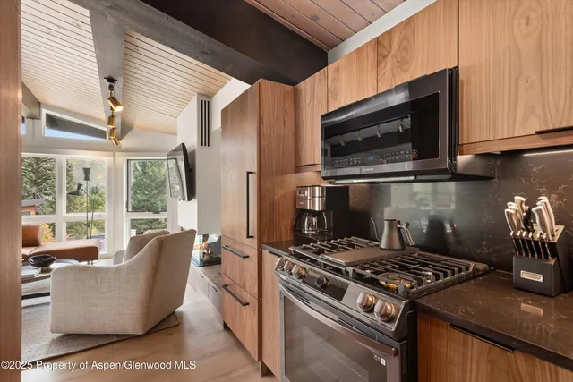 a kitchen with microwave a stove and cabinets