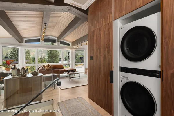 a living room with furniture a large window with kitchen view