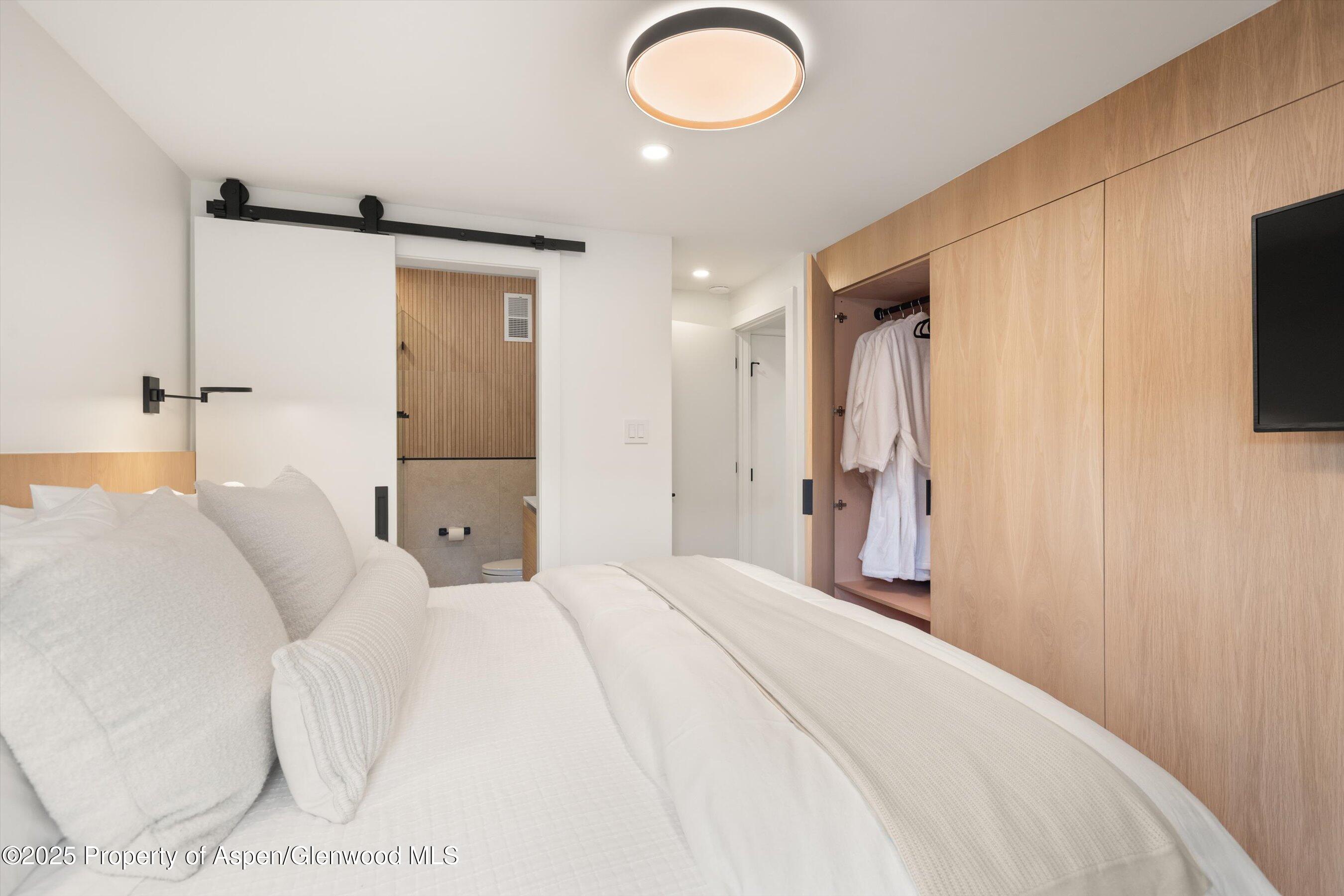 809 South Aspen Street, Unit 2 Aspen, CO 81611 - Photo 20 of 25 a bedroom with a bed and a flat tv screen