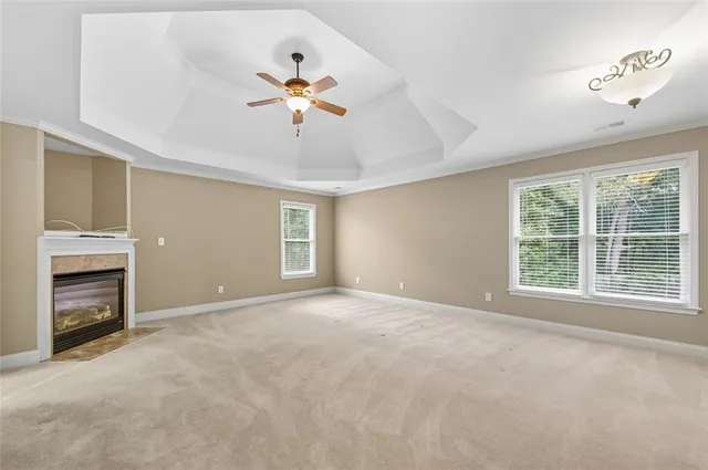 a view of an empty room with a fireplace and a window