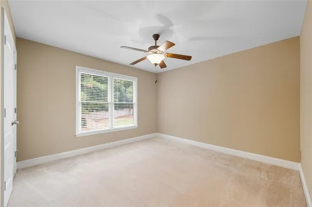 a view of a room with a ceiling fan and a window