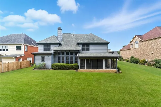 a view of a house with a big yard and large trees