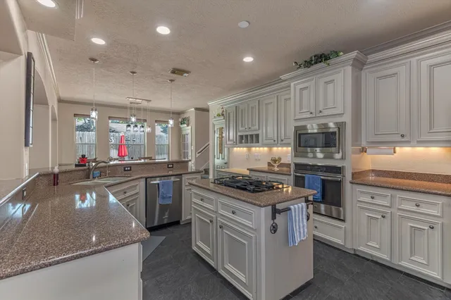a kitchen with a stove cabinets and wooden floor