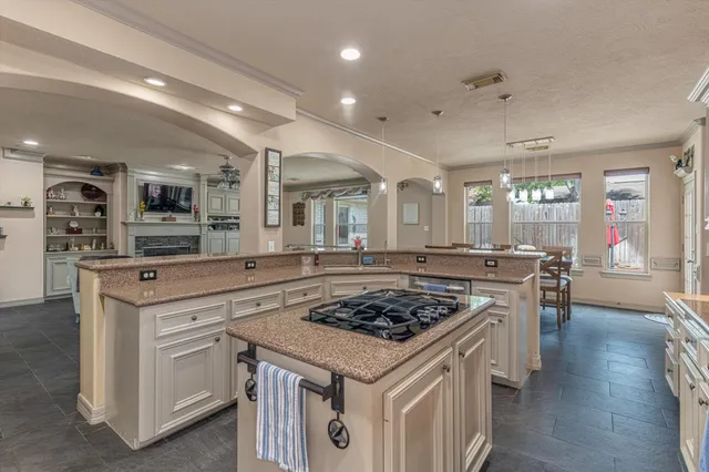 a kitchen with stainless steel appliances granite countertop a refrigerator and a stove top oven