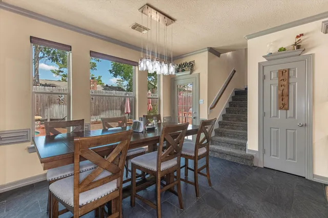 a dining room with kitchen island stainless steel appliances furniture a chandelier and kitchen view