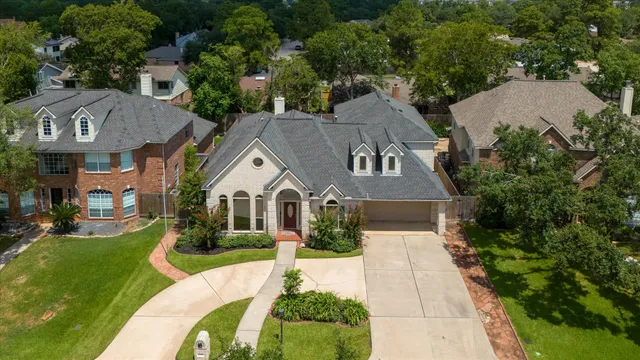 a aerial view of a house next to a big yard and large trees