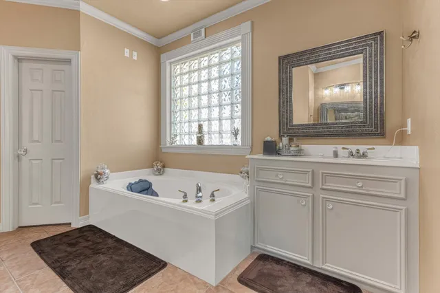 a bathroom with a tub a sink and a mirror