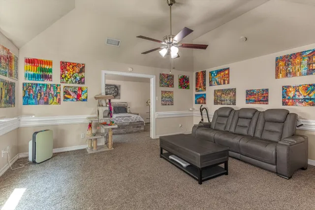 a living room with furniture and a ceiling fan