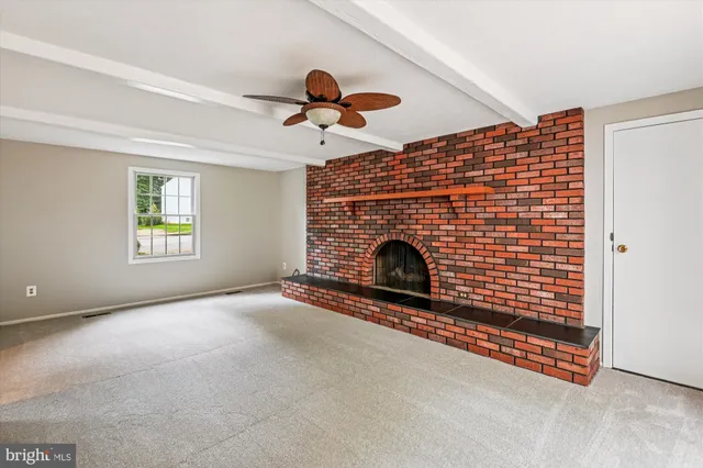 a view of empty room with fireplace and fan