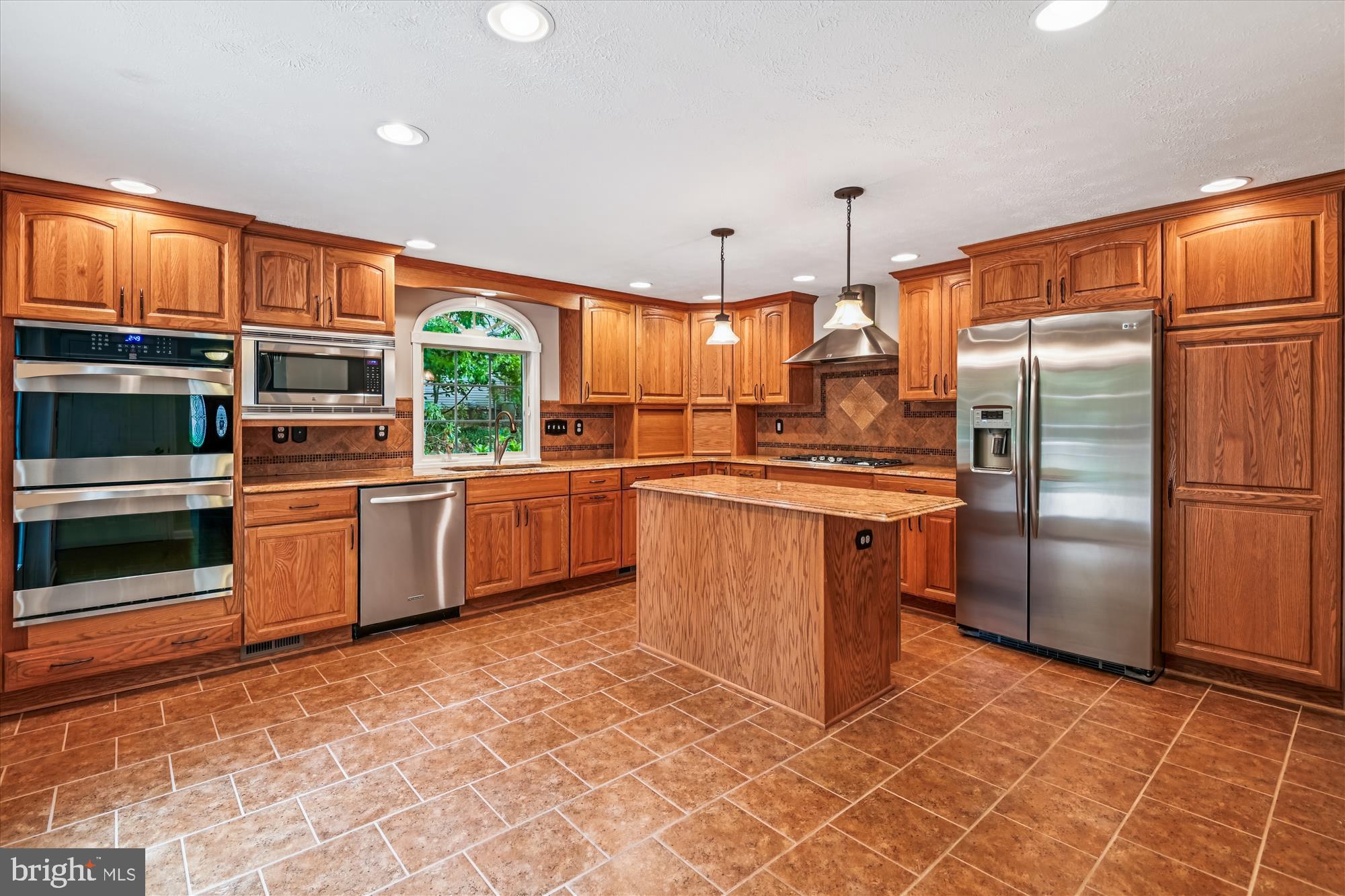 478 Bay Green Drive Arnold, MD 21012 - Photo 9 of 42 a kitchen with stainless steel appliances granite countertop a stove a sink dishwasher a refrigerator and a dining table with wooden cabinet
