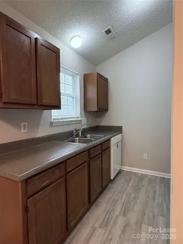 a kitchen with a sink cabinets and a wooden floor