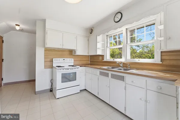a kitchen with granite countertop white cabinets and a sink