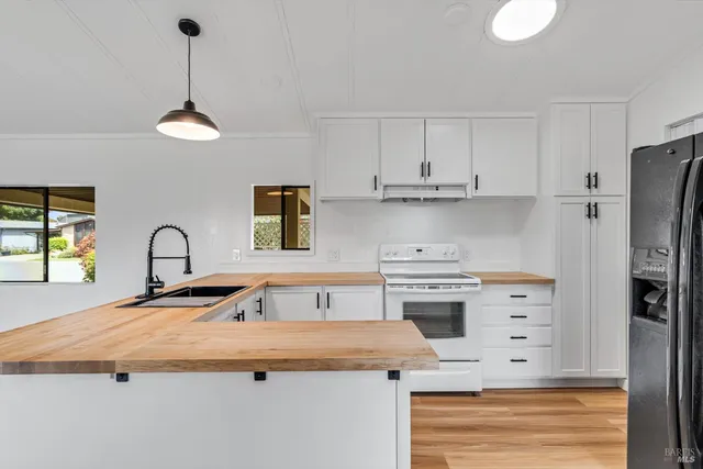 a kitchen with granite countertop a stove a sink and a refrigerator
