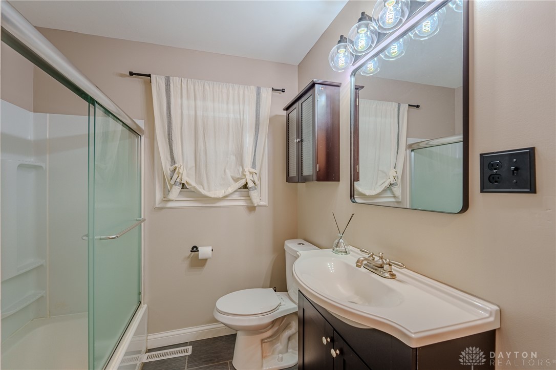 305 South Vandemark Road Sidney, OH 45365 - Photo 30 of 32 This bright bathroom features a vanity, mirror, toilet, and shower, perfect for daily routines.
