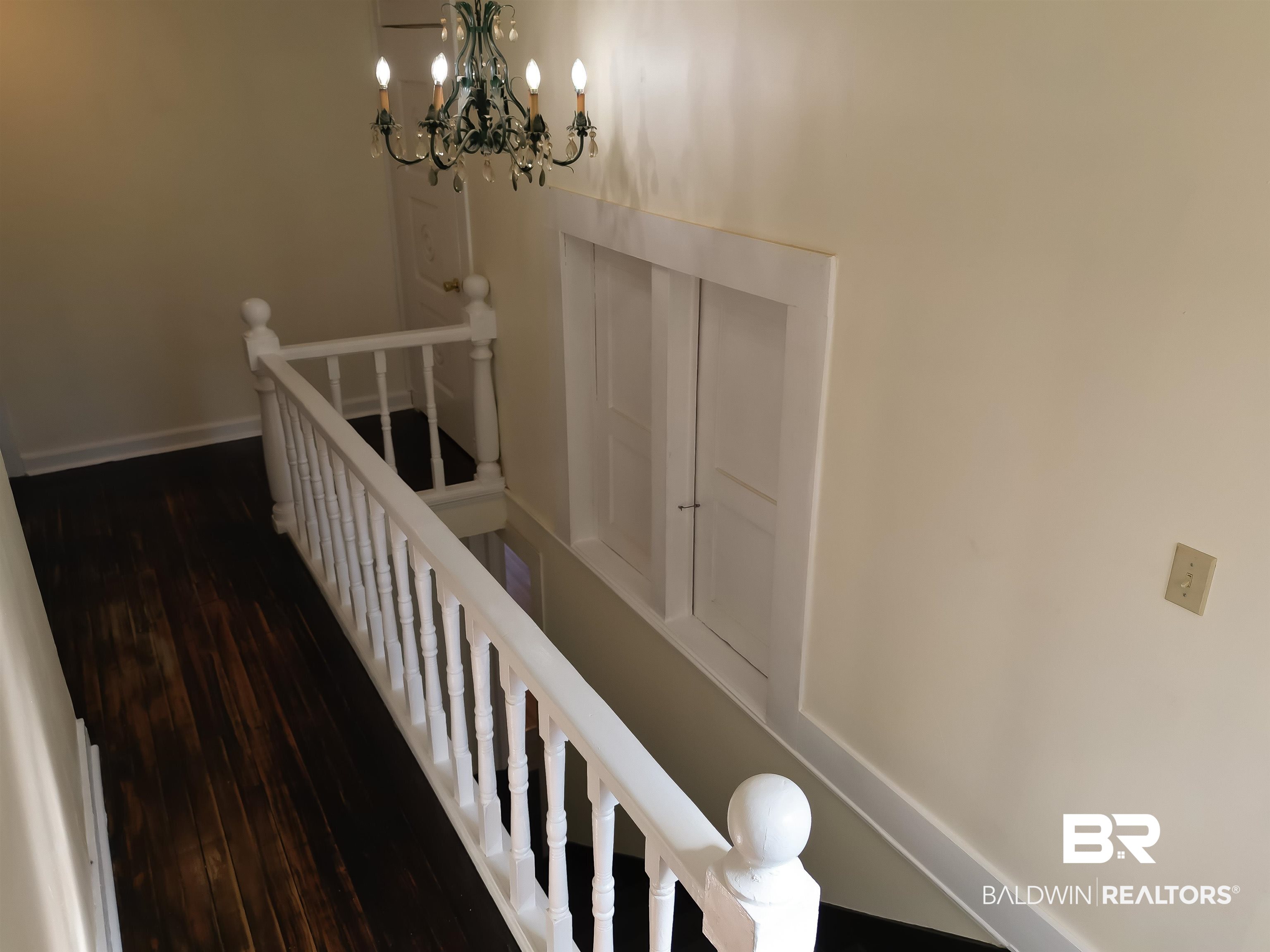 73 Liberty Street Monroeville, AL 36460 - Photo 15 of 29 Stairway featuring a notable chandelier and hardwood / wood-style floors