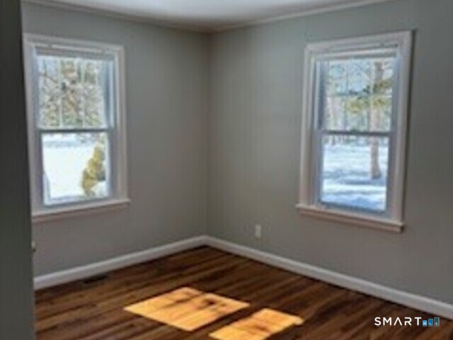 18 Buttonball Road Old Lyme, CT 06371 - Photo 13 of 20 an empty room with wooden floor and windows
