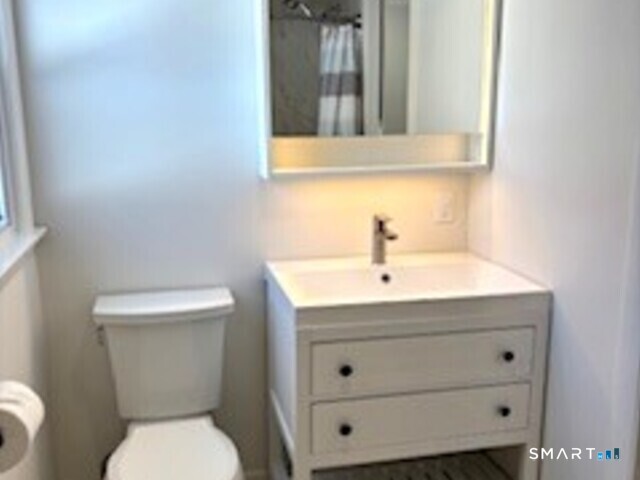 18 Buttonball Road Old Lyme, CT 06371 - Photo 16 of 20 a bathroom with a sink a toilet and mirror